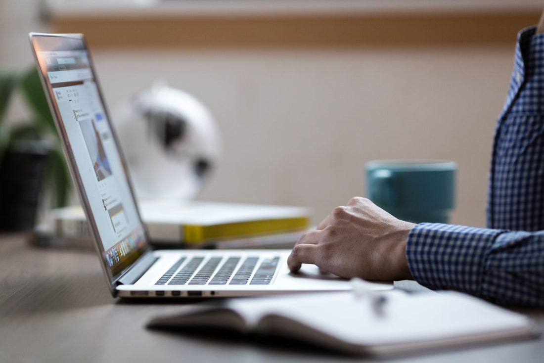 A laptop open on a desk, photographed from the side