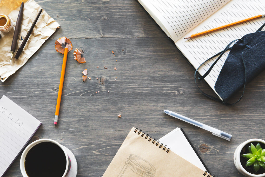 Notebook, pens and writing tools arranged on a desk