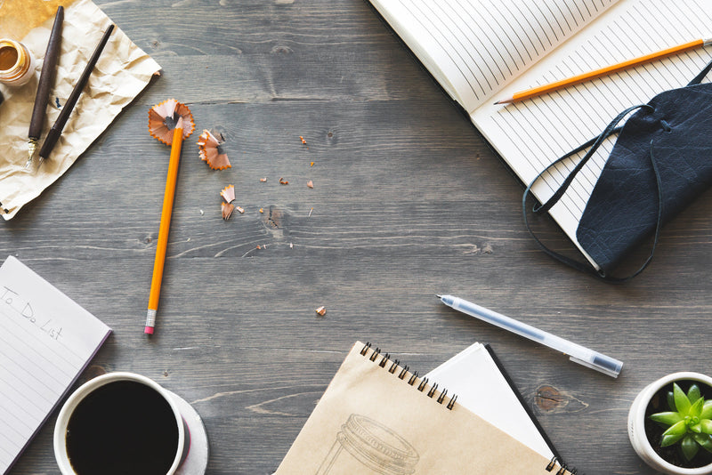 Notebook, pens and writing tools arranged on a desk